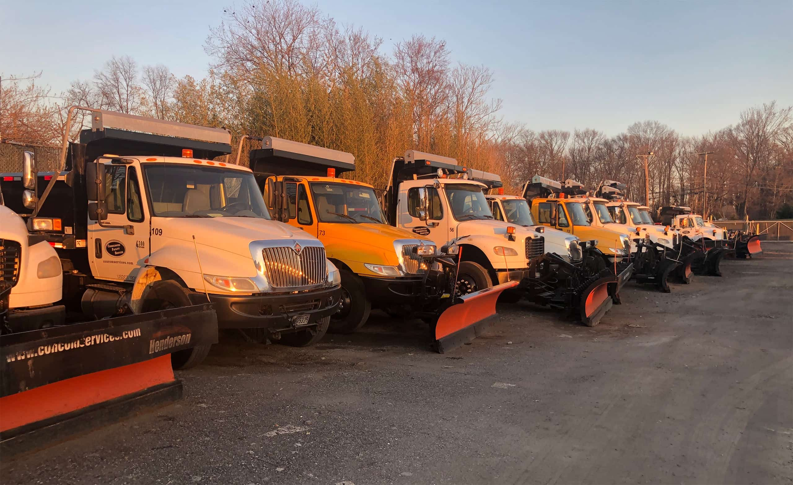 A row of trucks equipped with snow removal equipment