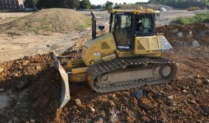 A bulldozer moving dirt and gravel on a job site
