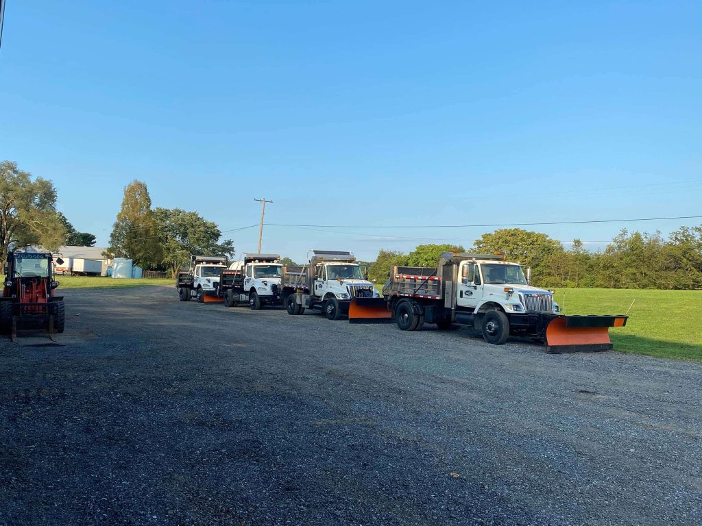 A row of trucks equipped with snow removal equipment